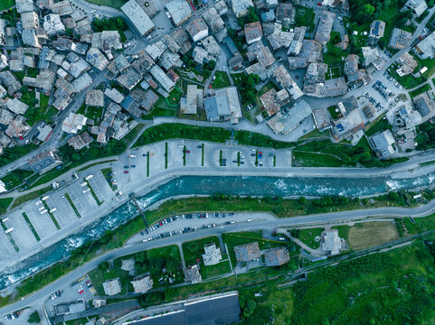 Aerial view of beautiful urban landscape with buildings, roads, and a river at sunset, Cogne, Italy.