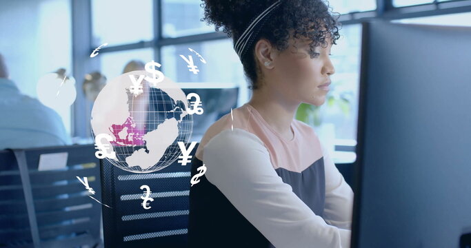 Image of currency icons and globe over biracial woman using computer - Powered by Adobe