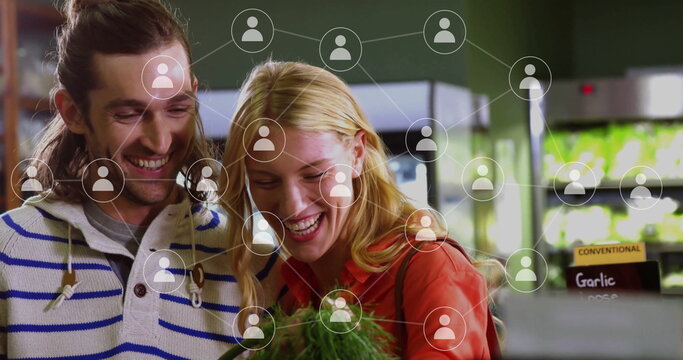 Image of data processing with icons over caucasian couple grocery shopping - Powered by Adobe