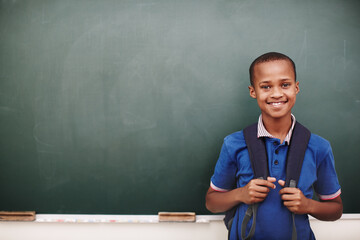 Education, portrait and smile of student on chalkboard in school classroom for child development, future or growth. Face, learning and study with happy boy on mockup space for lesson or scholarship