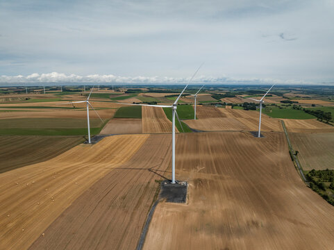 Aerial view of wind turbines amidst green fields and a clear sky, Son, Ardennes, France.