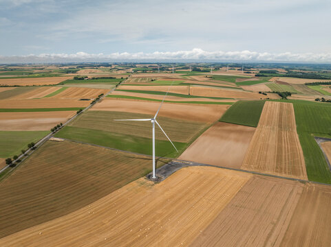 Aerial view of wind turbines amidst green fields in Son, Ardennes, France.