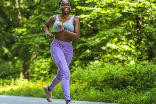 Woman, runner and fitness on mountain with music for wellness workout or cardio training with audio motivation. Black woman, athlete and listening or streaming radio podcast, sports running outdoor.