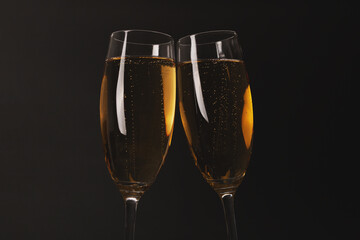 Two glasses of champagne glasses on luxury black background.