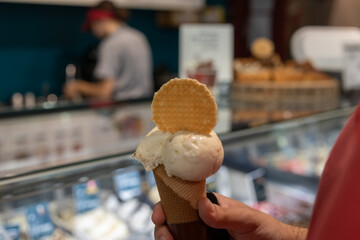 hand holding chocolate ice cream cone close up isolated