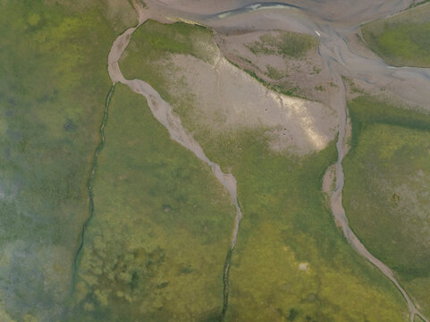 Aerial view of beautiful patterns and shapes of the river and stream at low tide, Holy Island, Berwick-upon-Tweed, England.