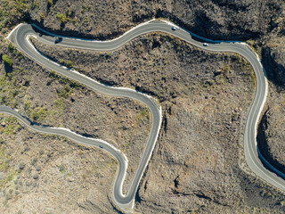 Aerial view of winding roads on the west coast of Gran Canaria, the least urbanized coast. Province of Mogan. Desert land with little vegetation, mountains alternate with sparsely inhabited valleys.