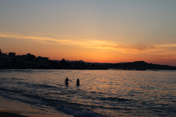 bathing in the sea at sunset