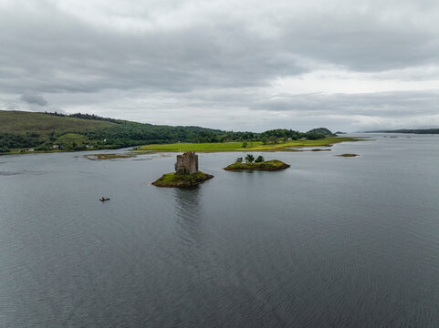 Aerial view of castle stalker on an island in loch linnhe surrounded by serene and tranquil landscape, Appin, United Kingdom.