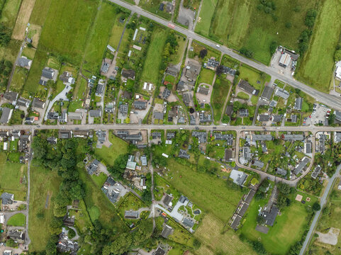 Aerial view of Loch Leven with beautiful village and homes surrounded by greenery and fields, Glencoe, Scotland.