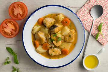 Hake stew with potatoes and carrots. Top view table with  decorations.