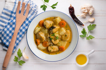 Hake stew with potatoes and carrots. Top view table with  decorations.
