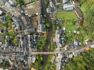 Aerial view of beautiful buildings and streets alongside a river and bridge with greenery, Malmedy, Belgium.