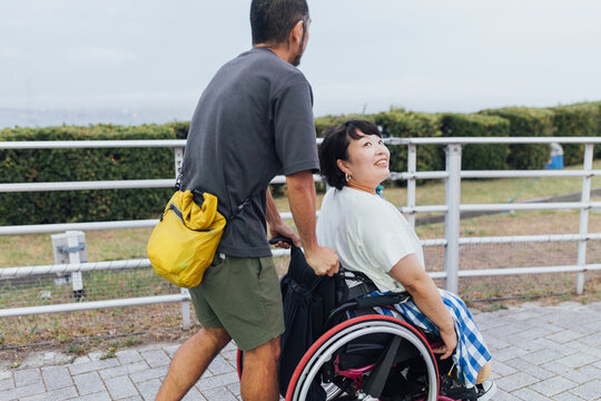 日本人の車椅子に乗った女性が夫の顔を覗き込んでいる