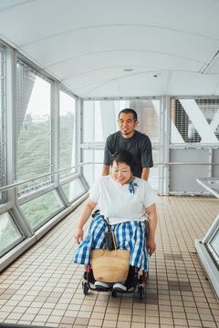 日本人女性の乗った車椅子を彼氏が押しながら旅を楽しんでいる