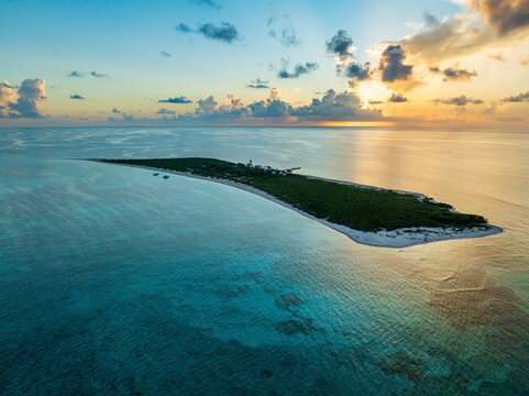 Aerial view of Alacranes Reef at sunset with tranquil turquoise waters and serene sandy shores, Progreso, Mexico.