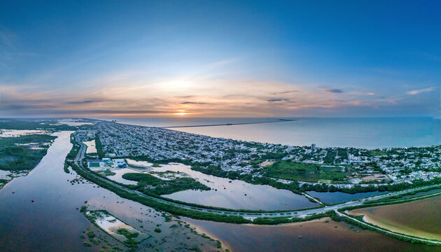 Aerial view of a tranquil sunset over the coastline with beautiful homes and calm ocean, Progreso, Yucatan, Mexico.