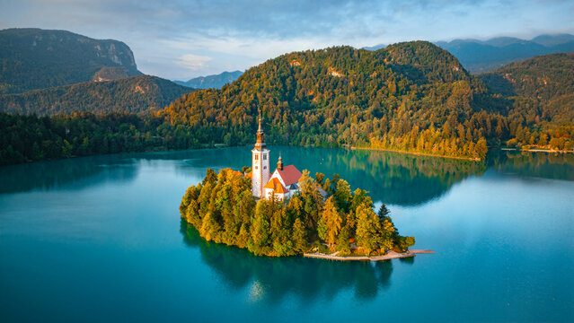 Aerial drone view of Lake Bled with famous church on the island during sunrise, Slovenia