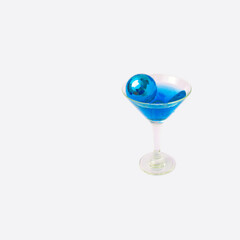 Disco ball on blue drink in glass bright background. Creative concept.