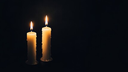 Two glowing candles illuminate a dark space, creating a serene and peaceful ambiance perfect for relaxation and reflection.