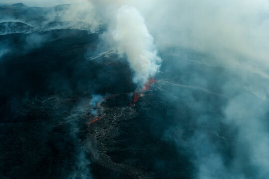 Aerial view of the majestic Fagradalsfjall volcano with smoke and lava amidst a scenic landscape, Grindavik, Iceland.