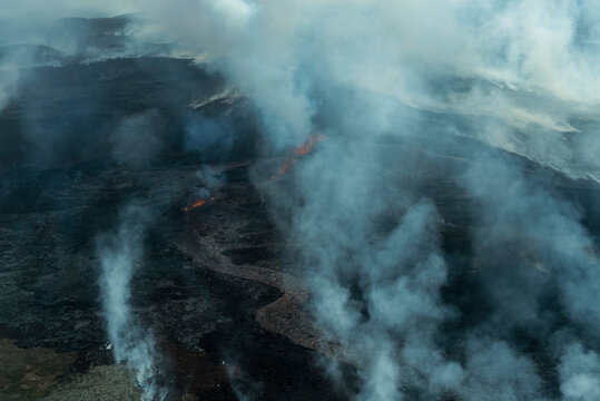Aerial view of majestic Fagradalsfjall volcano with flowing lava and smoke in a scenic landscape, Reykjanes Peninsula, Iceland.