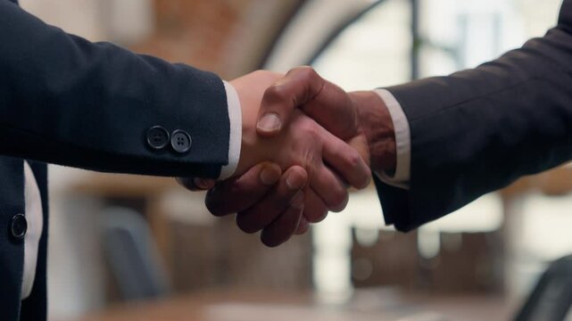 Close up males hands shake handshaking office negotiation hire candidate two unrecognizable men business meeting businessmen multiracial partners insurance loan bank teamwork partnership cooperation