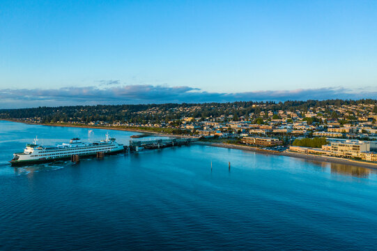 Aerial view of washington state ferry navigating through tranquil puget sound with beautiful skyline of edmonds, washington, united states.