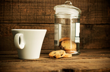 A coffee with milk and cookies on a wooden background