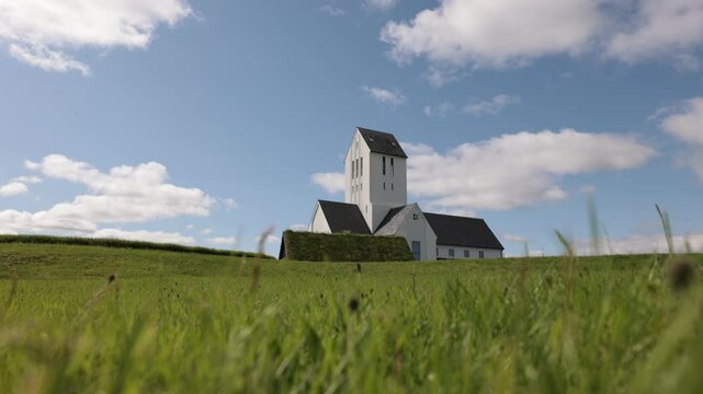 Timelapse of Magnificent Lutheran church or cathedral in Skalholt area of Iceland on a warm summer day. Majestic church in the middle of green fields and plains.