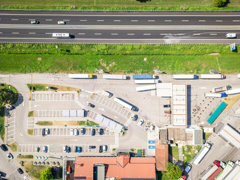 Aerial view of a busy motorway with a gas station and trucks, Cessalto, Italy.