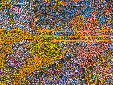 Aerial view of vibrant dahi handi festival with a colorful crowd and human towers, Thane, India.