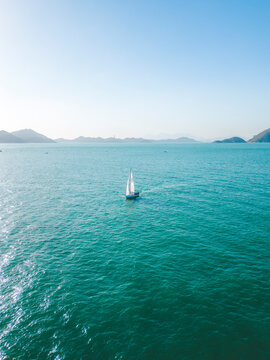 Aerial view of beautiful sailboats on the blue ocean with a coastal landscape, Chung Hom Kok, Hong Kong.