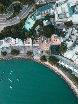 Aerial view of coastal skyline with buildings, boats, and greenery along the shore, Chung Hom Kok, Hong Kong.