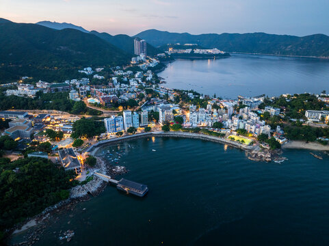 Aerial view of serene coastal town with beautiful architecture and tranquil ocean at sunset, Chung Hom Kok, Hong Kong.