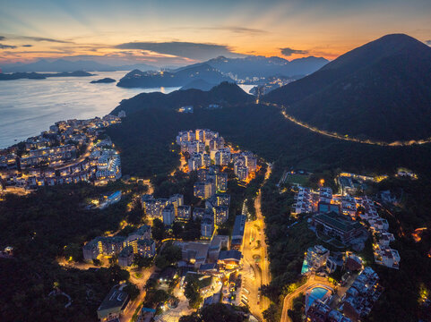 Aerial view of a beautiful dusk cityscape with mountains and a serene coastline, Chung Hom Kok, Hong Kong.