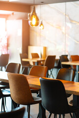 Cozy and modern coffee shop interior with wooden furniture, warm lighting, and large windows overlooking the street, creating an inviting atmosphere