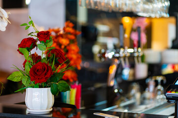 Cozy and modern coffee shop interior with wooden furniture, warm lighting, and large windows overlooking the street, creating an inviting atmosphere
