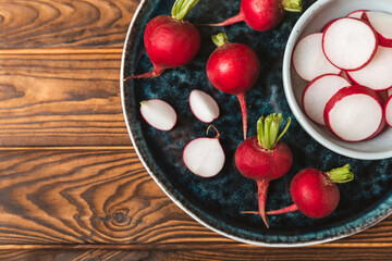 Fresh radish on textured wooden background. Organic natural garden radish slices. clipping root crop. Vegetables. Vegan. Diet products. Healthy food. Place for text. Copy space.