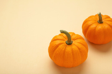 Mini orange pumpkins on beige background. Space for text