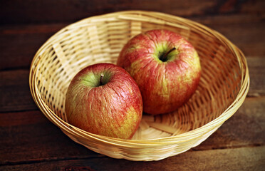 A pair of red apples in a basket
