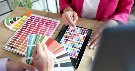 Closeup of fellow interior designers working with color palette and blueprint. Designer and client planning joint discussion banner creative concept for website header design