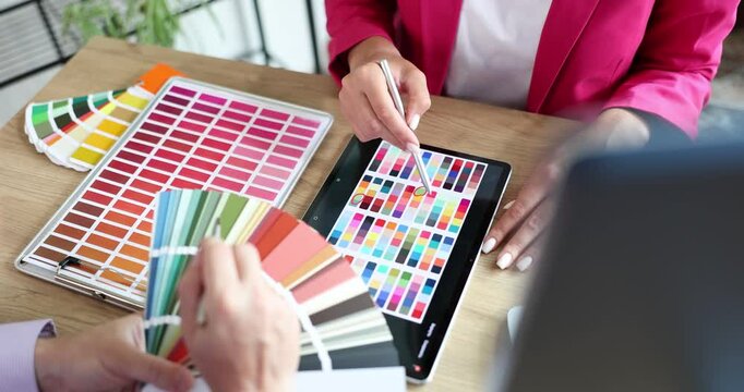 Closeup of fellow interior designers working with color palette and blueprint. Designer and client planning joint discussion banner creative concept for website header design