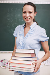 Math class, happy teacher and books for education, learning and problem solving for development. Woman, portrait and classroom for solution, confidence or smile with chalkboard for school knowledge