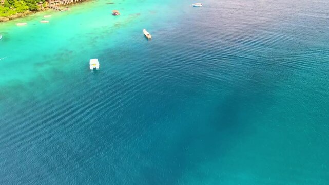 Boats Docked by a Pier with Stunning Emerald Green Seaside Views