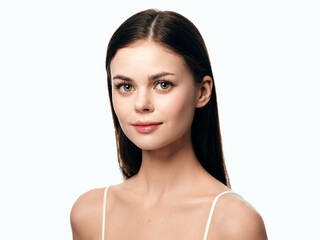 Fototapeta premium Attractive young woman with long dark hair posing for the camera on a white background