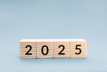 2025 on Wooden blocks isolated on blue background. Copy space
