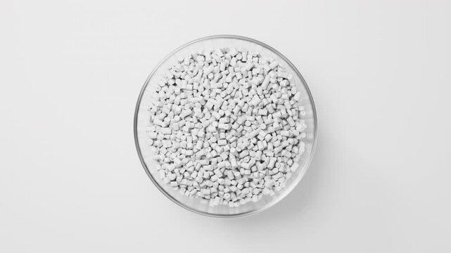 Rotating glass bowl with white plastic polypropylene granules, masterbatch polymer grain on white backdrop. HDPE or PVC resin pellets. 3d render animation