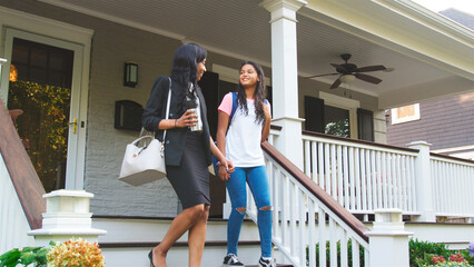 Businesswoman Mother Leaving Home Walking Daughter To School On Way To Work