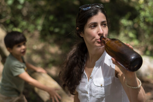Woman drinking beer in big beer bottle